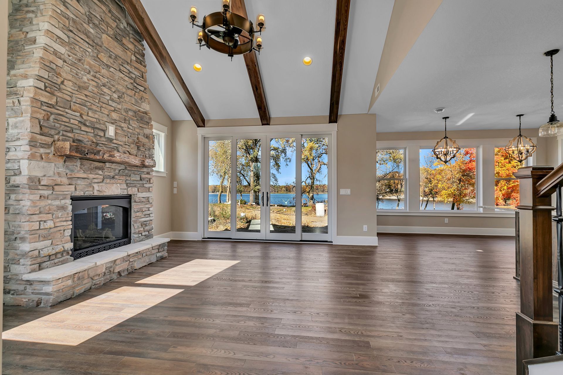 An empty living room with a fireplace and sliding glass doors.