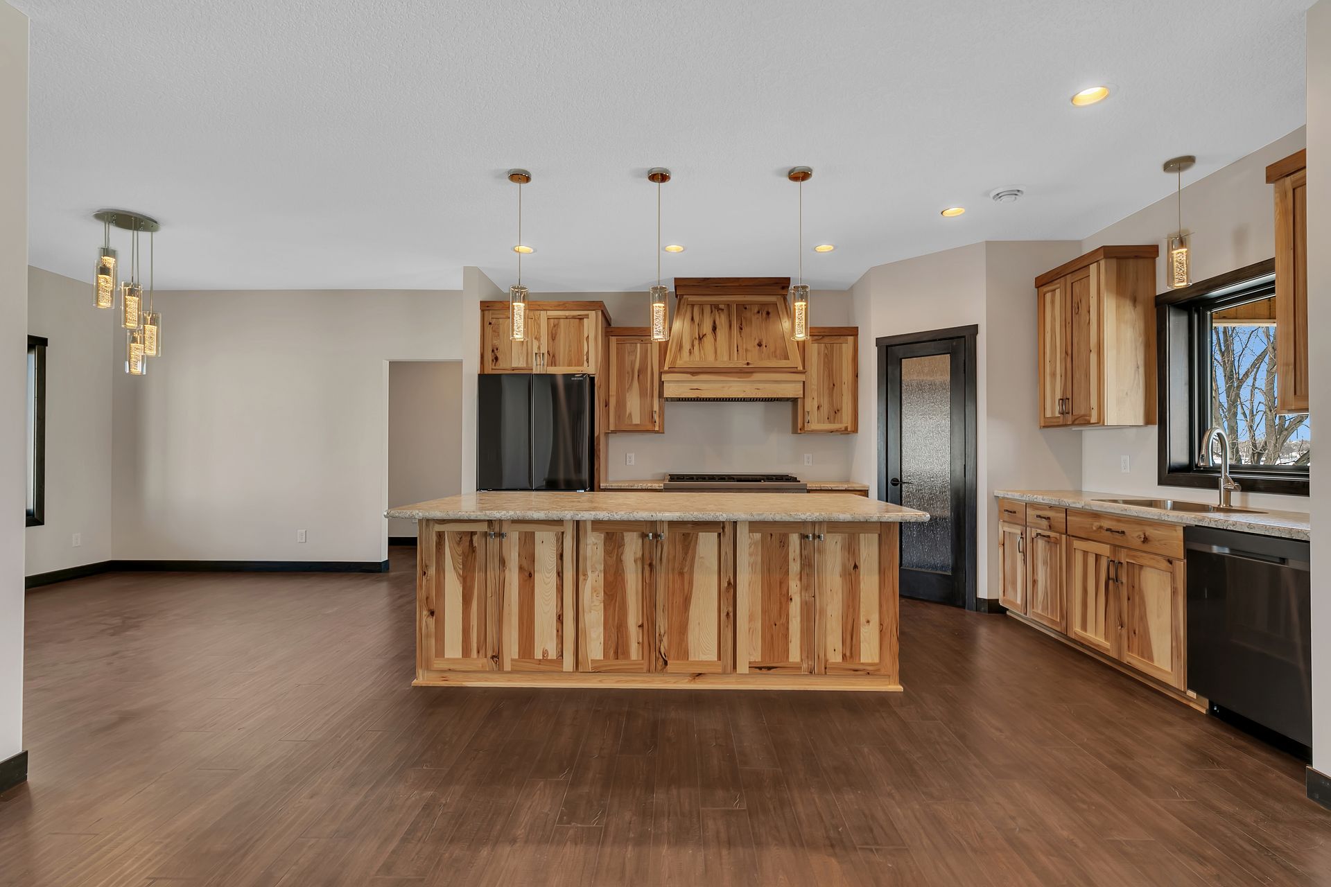 An empty kitchen with wooden cabinets and a large island.