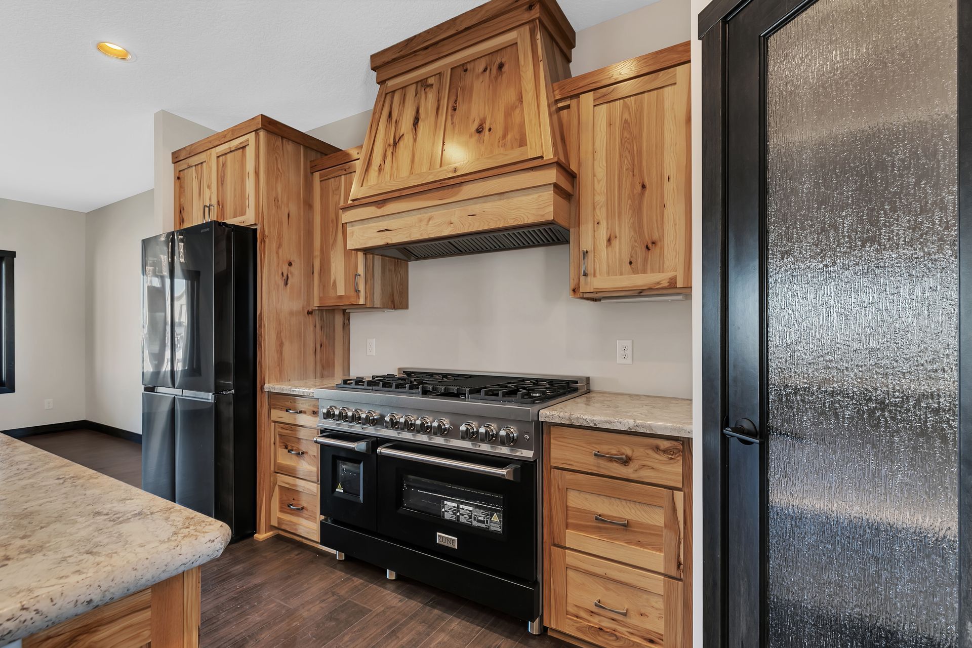 A kitchen with wooden cabinets , a stove and a refrigerator.
