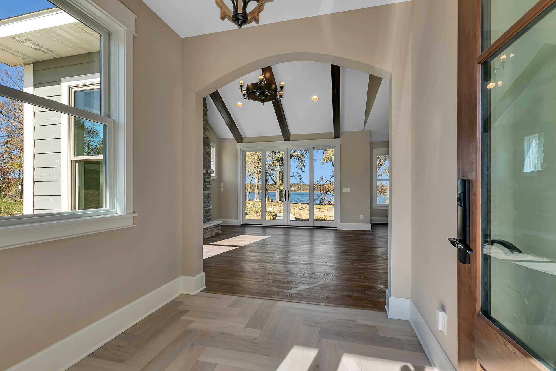 A hallway in a house with sliding glass doors and a chandelier.