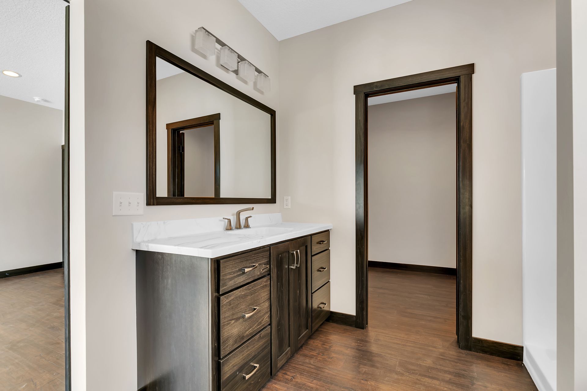 A bathroom with a sink , mirror and cabinets.