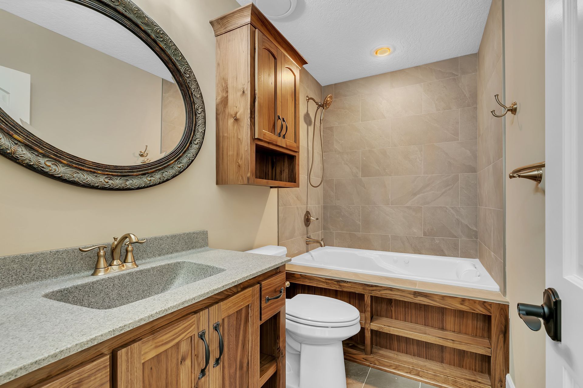 A bathroom with a sink , toilet , tub and mirror.