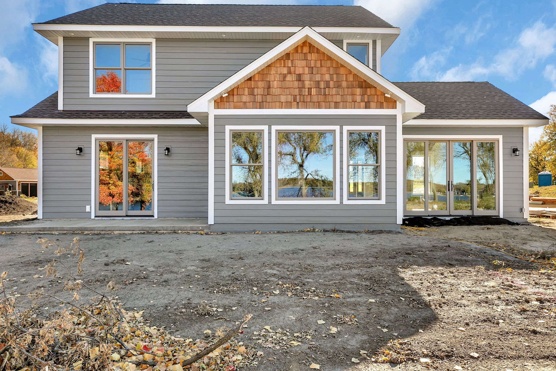 A house with a lot of windows and a lot of gravel in front of it