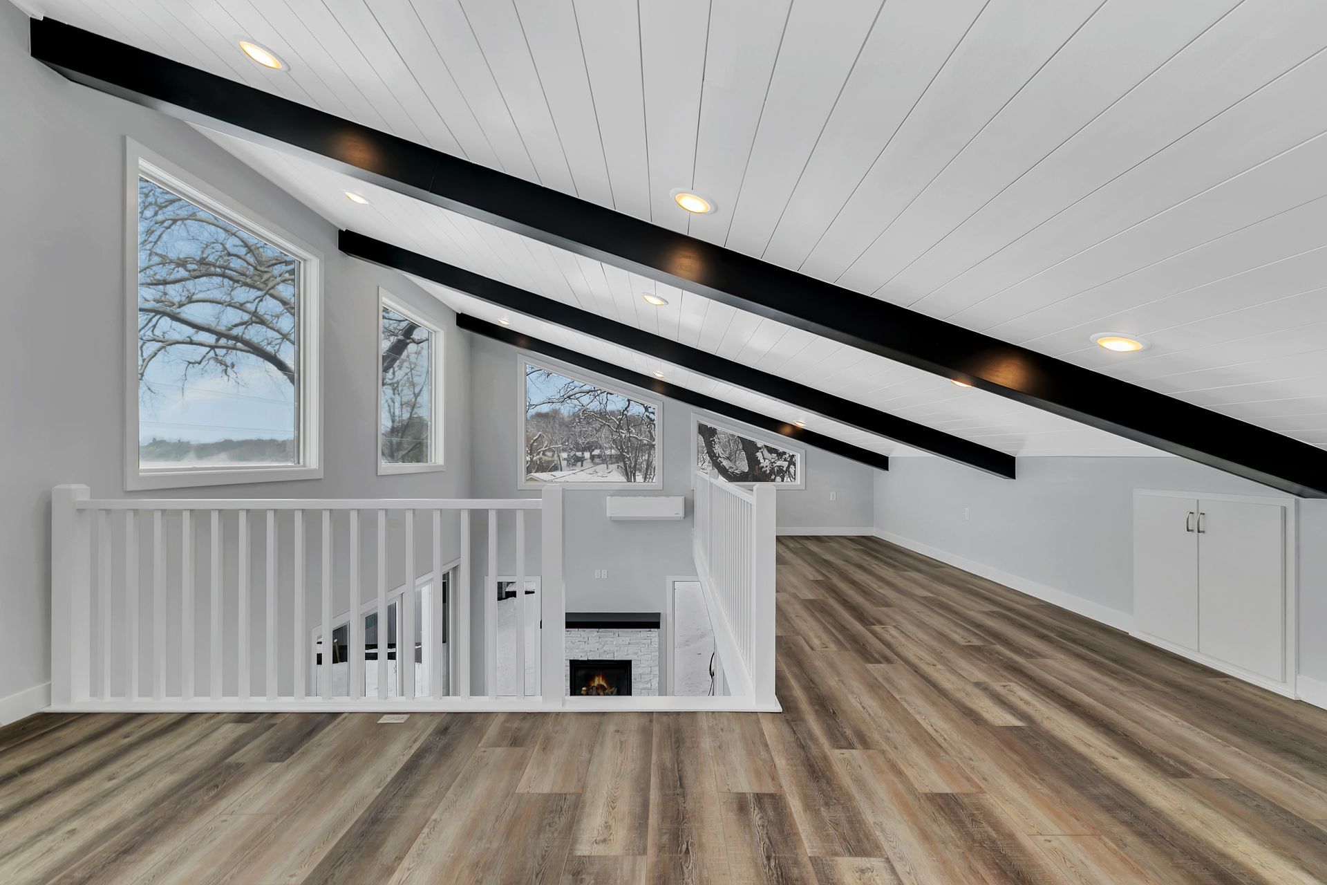 An empty room with hardwood floors and a fireplace.