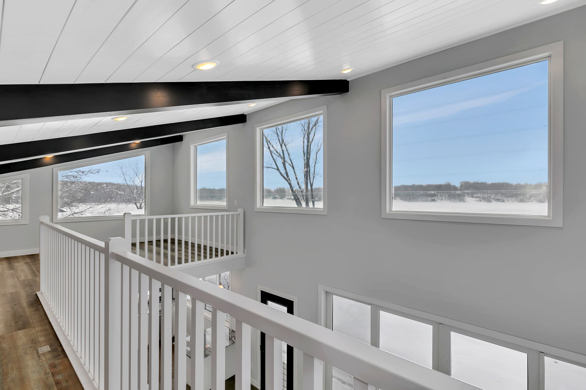 A balcony with a railing and lots of windows in a house.