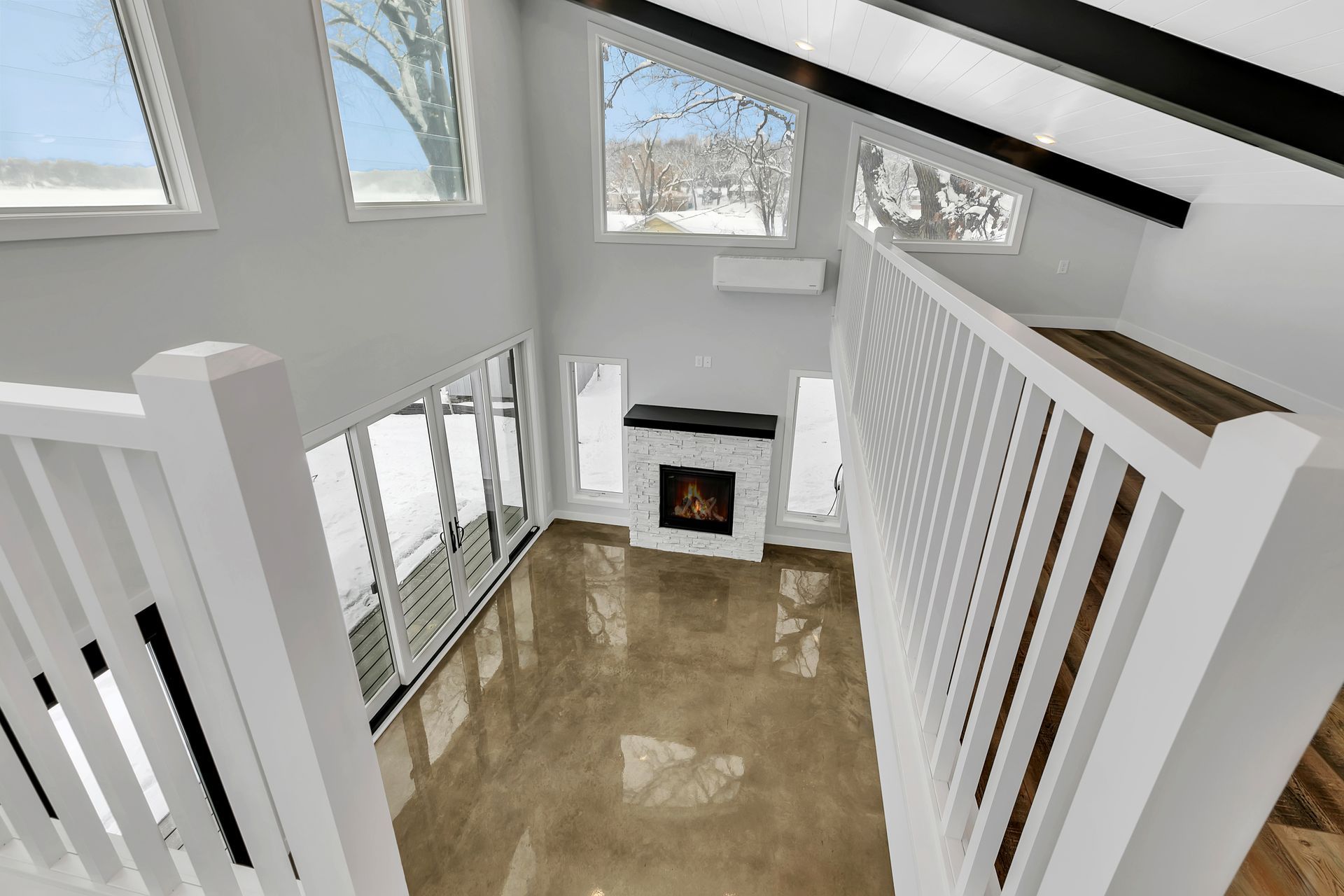 An aerial view of a living room with a fireplace and stairs
