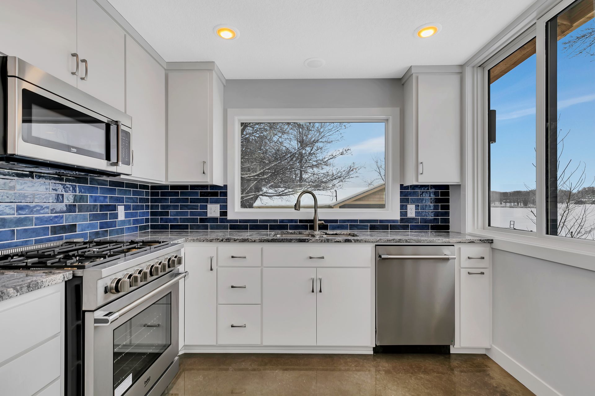 A kitchen with white cabinets and stainless steel appliances