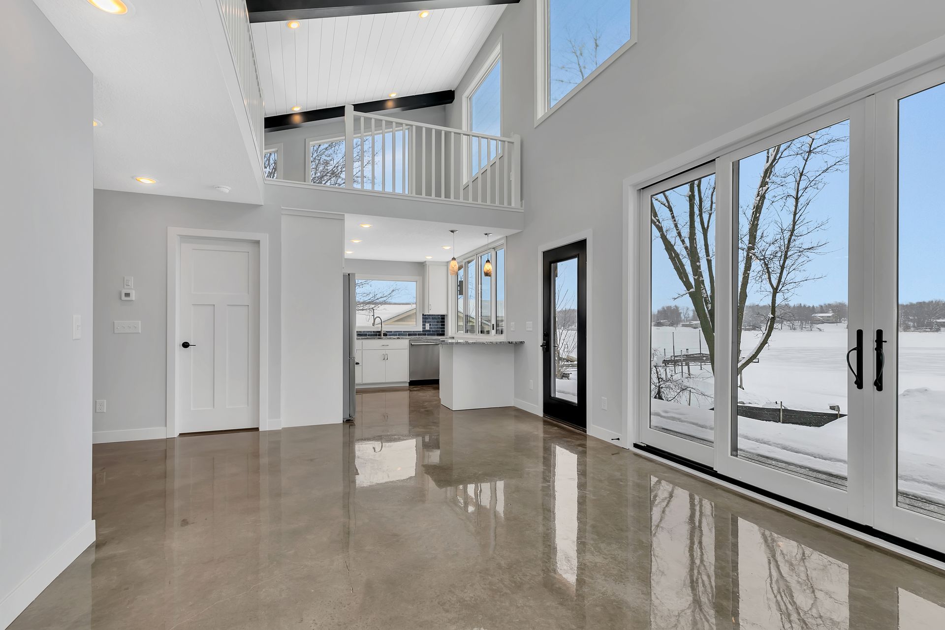 A large empty room with a lot of windows and a view of a lake.