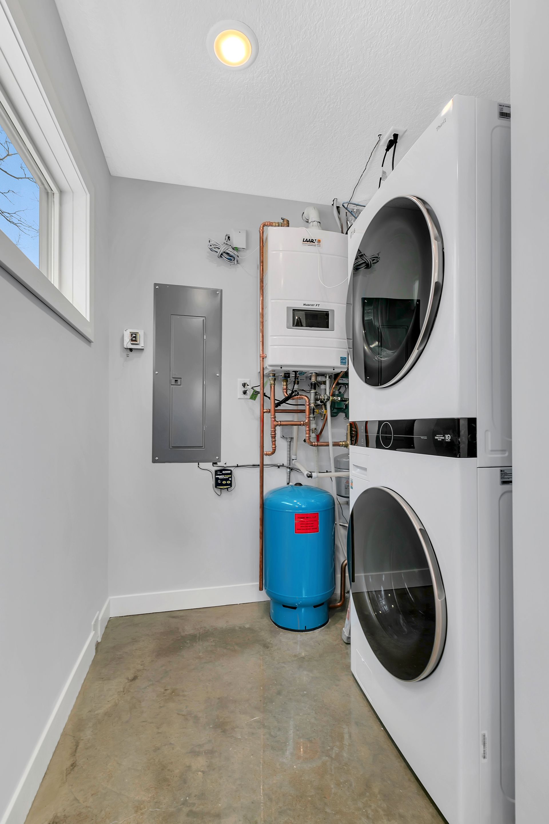 A laundry room with a washer and dryer stacked on top of each other.