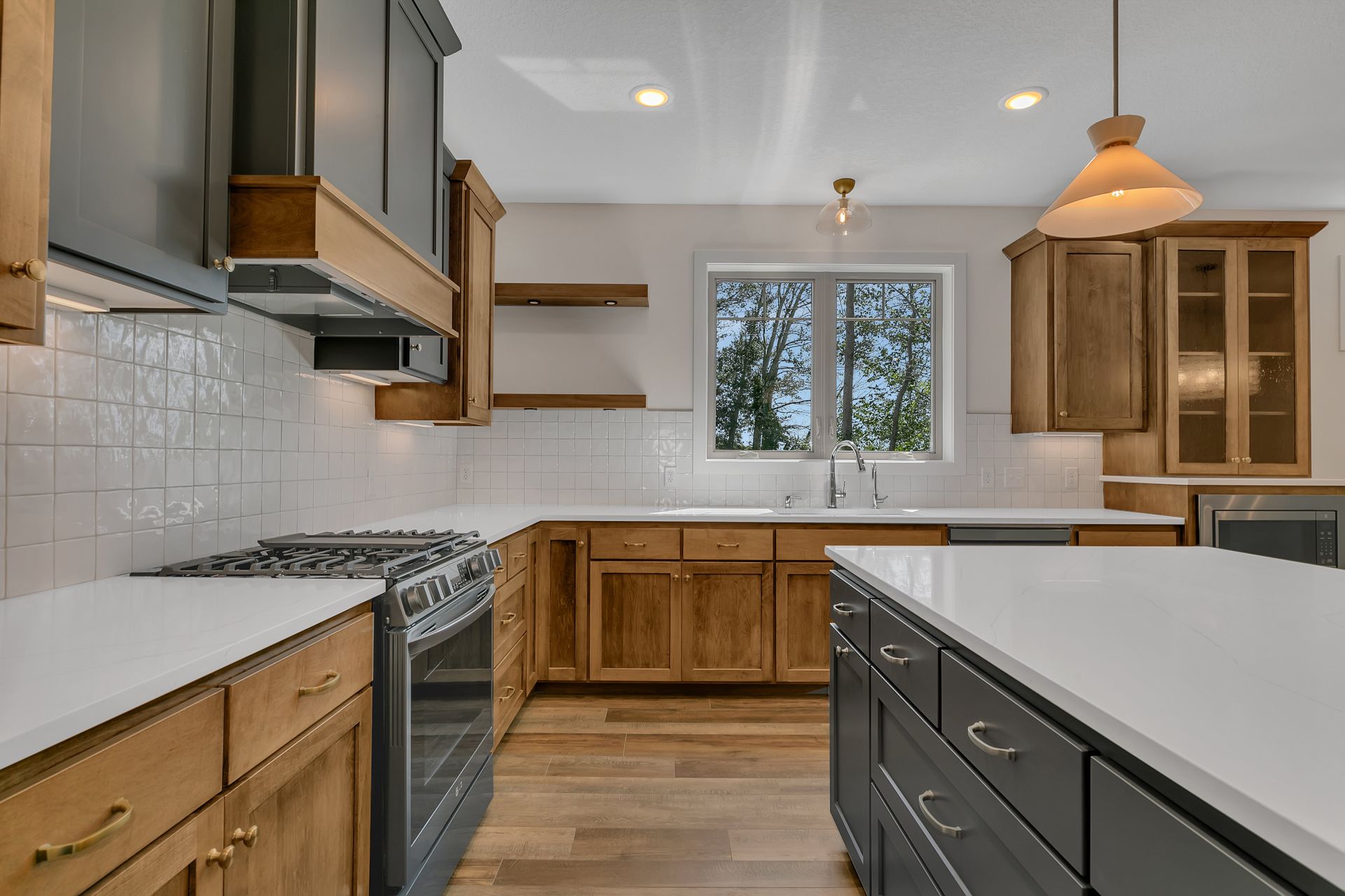 A kitchen with wooden cabinets , a stove , a sink , and a large island.