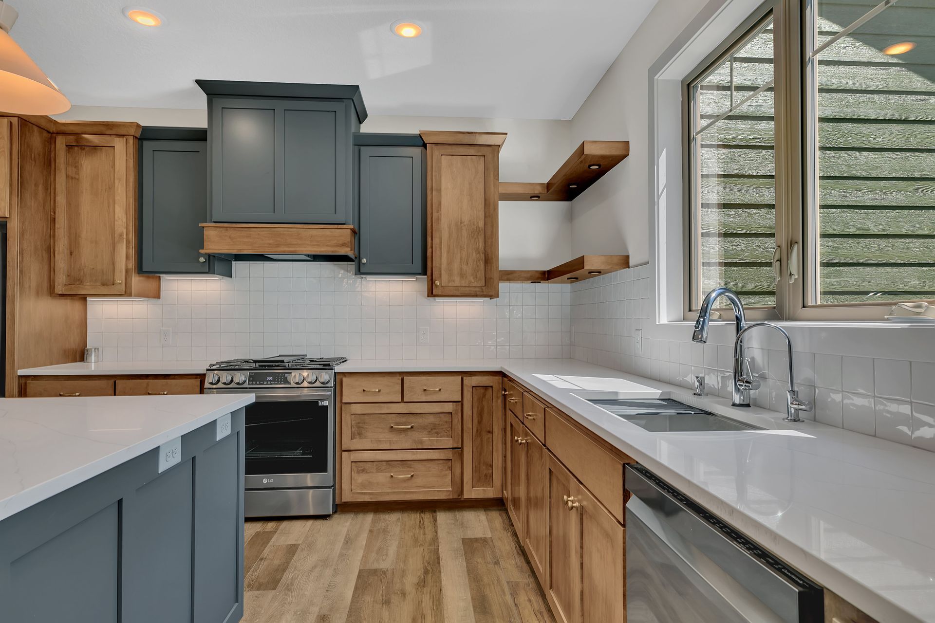 A kitchen with wooden cabinets , stainless steel appliances , a sink , and a window.