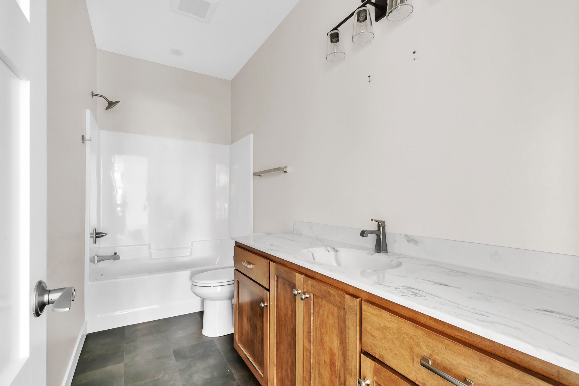 A bathroom with a toilet , sink , and bathtub.