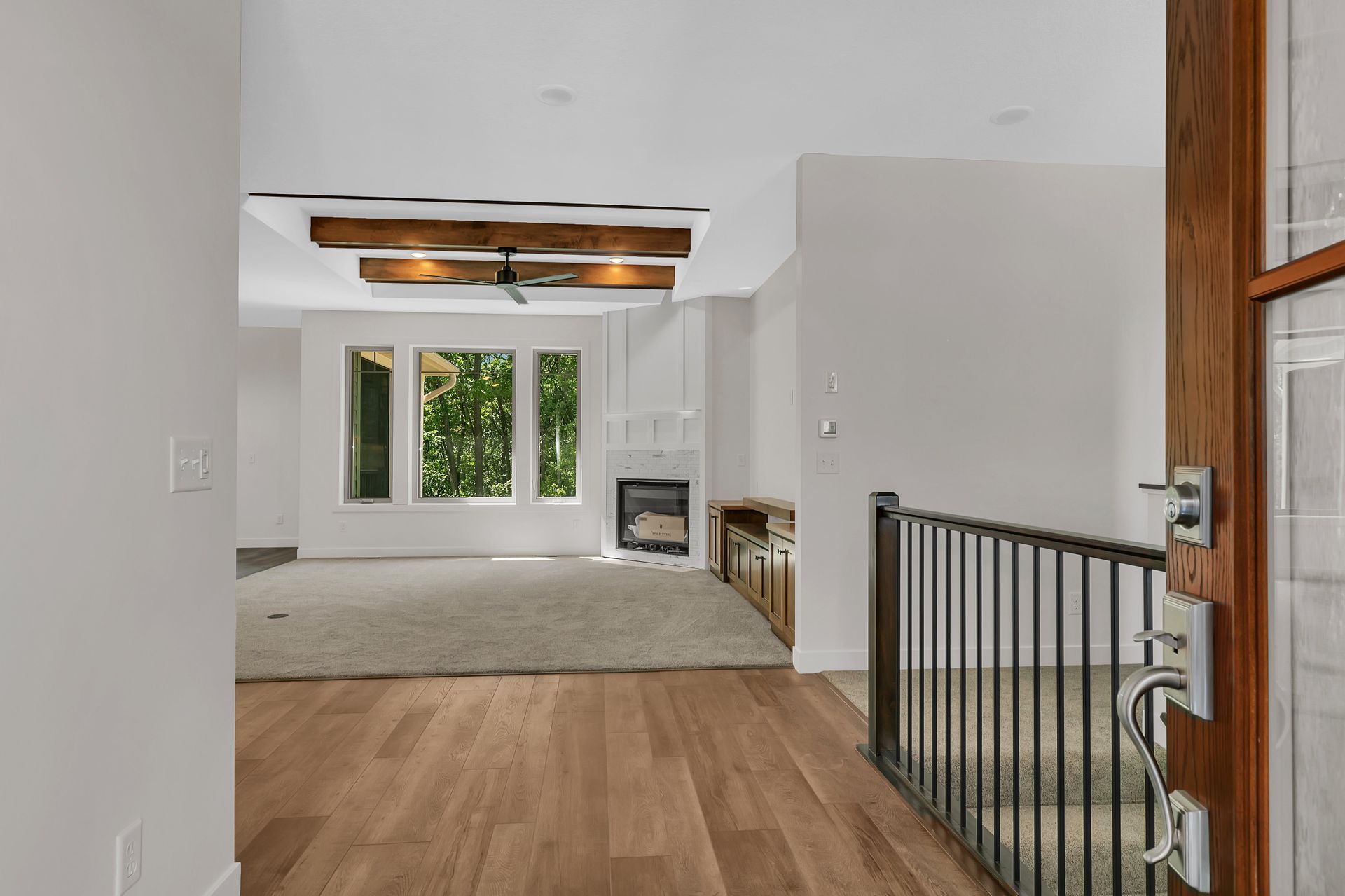 A doorway leading to a living room with hardwood floors and a fireplace.