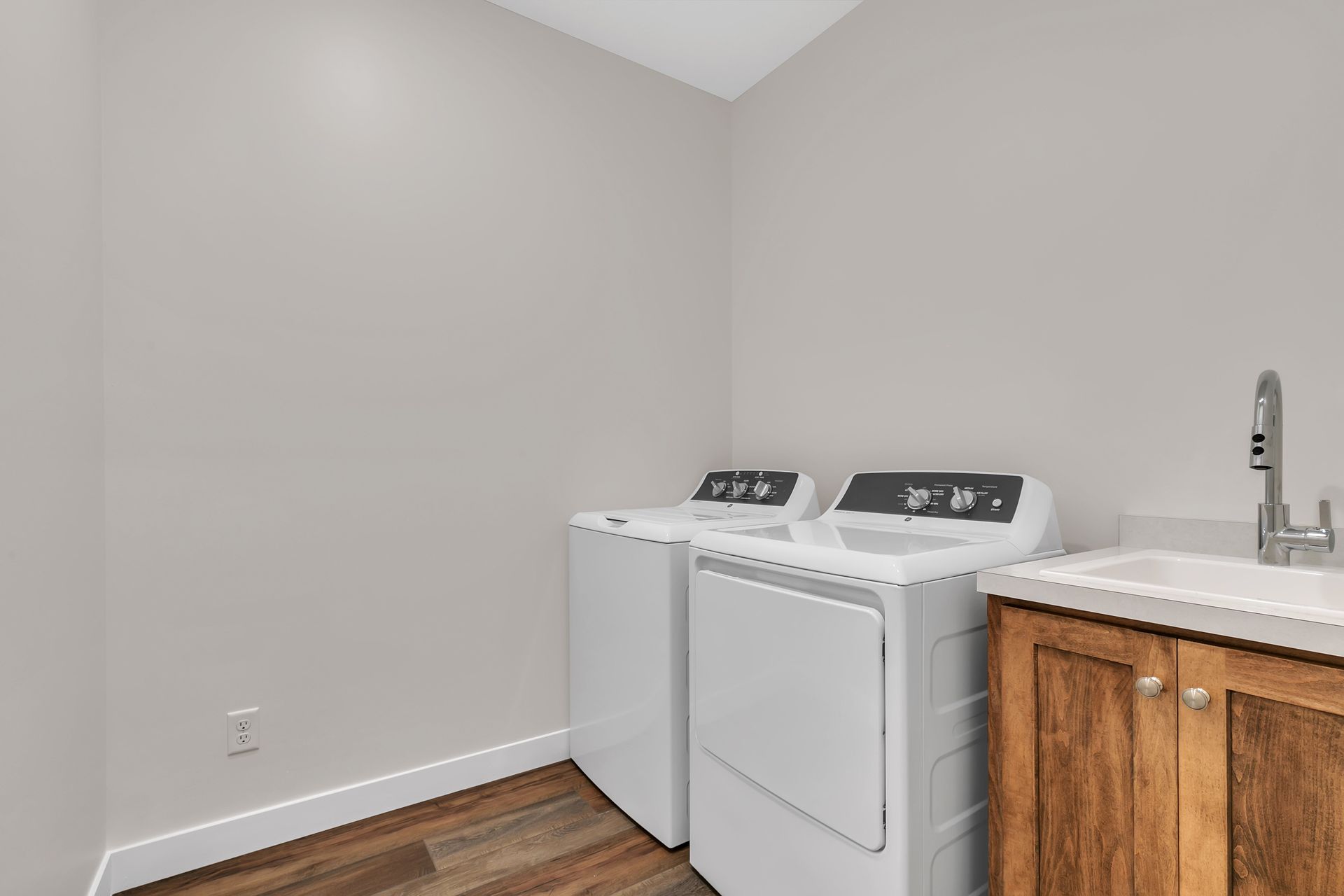 A laundry room with a washer and dryer and a sink.