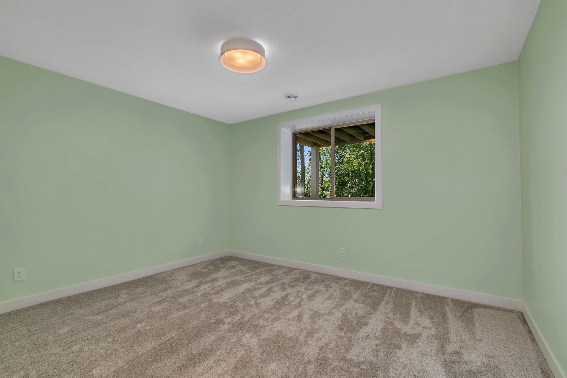 An empty room with green walls and a window.
