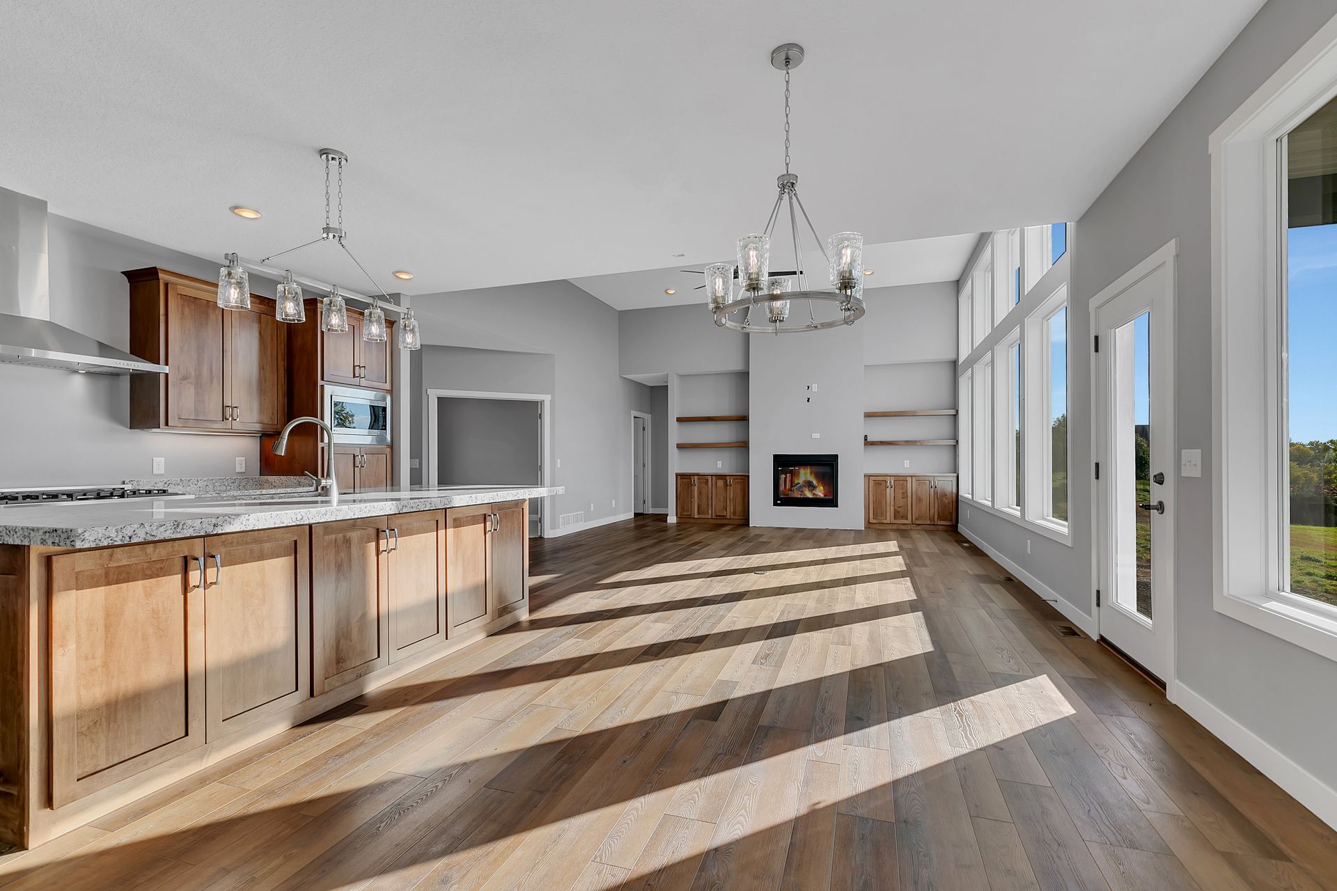 A large empty kitchen with hardwood floors and a fireplace.