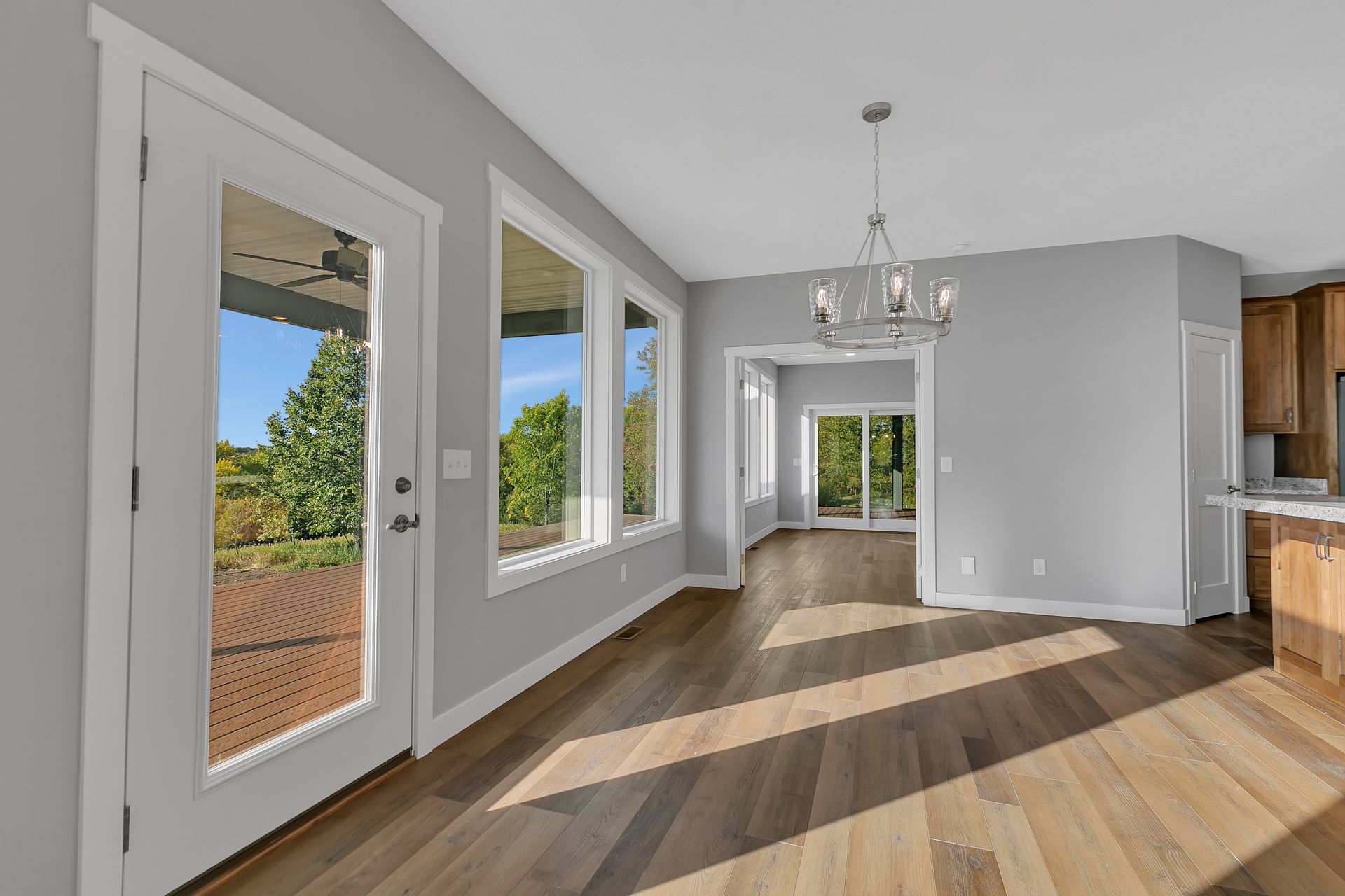 An empty living room with hardwood floors and sliding glass doors.