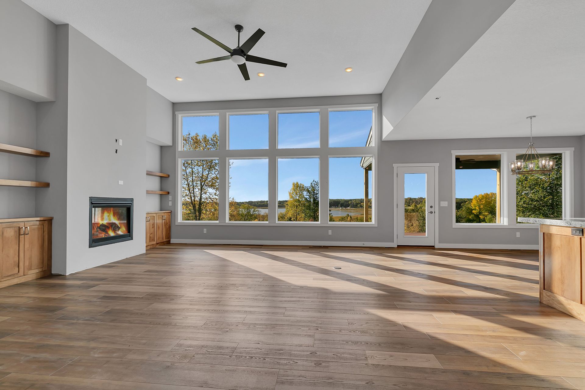 An empty living room with a fireplace and a ceiling fan