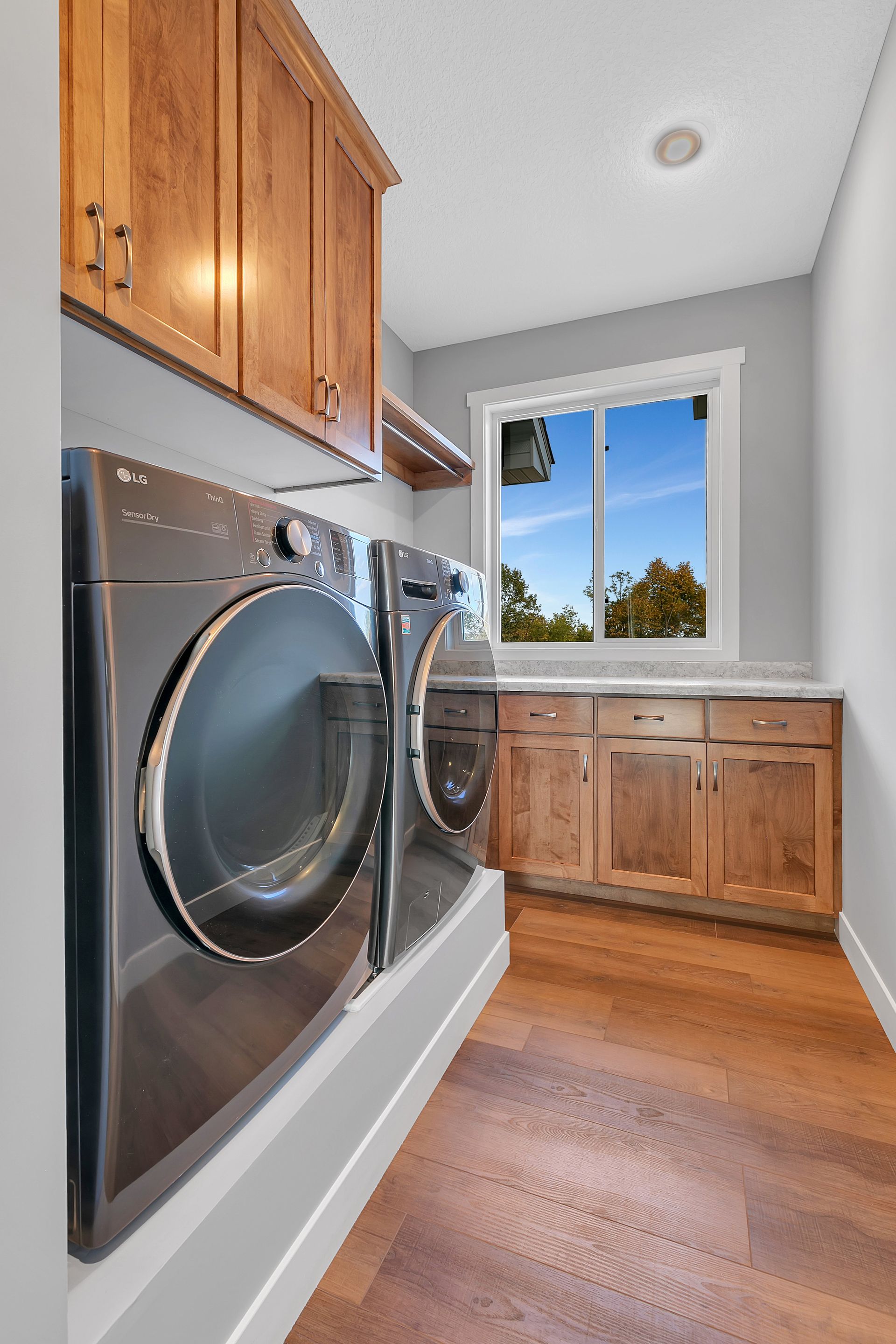 A laundry room with a washer and dryer and a window.