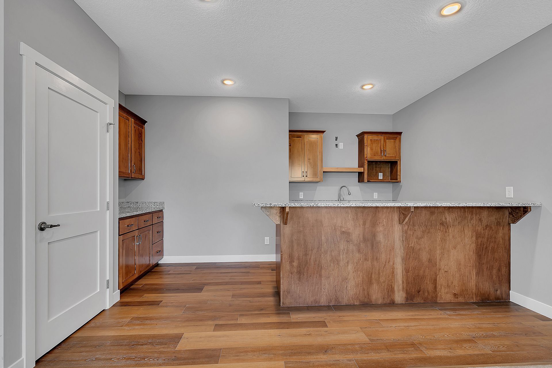 A kitchen with wooden cabinets and a large island in the middle of the room.