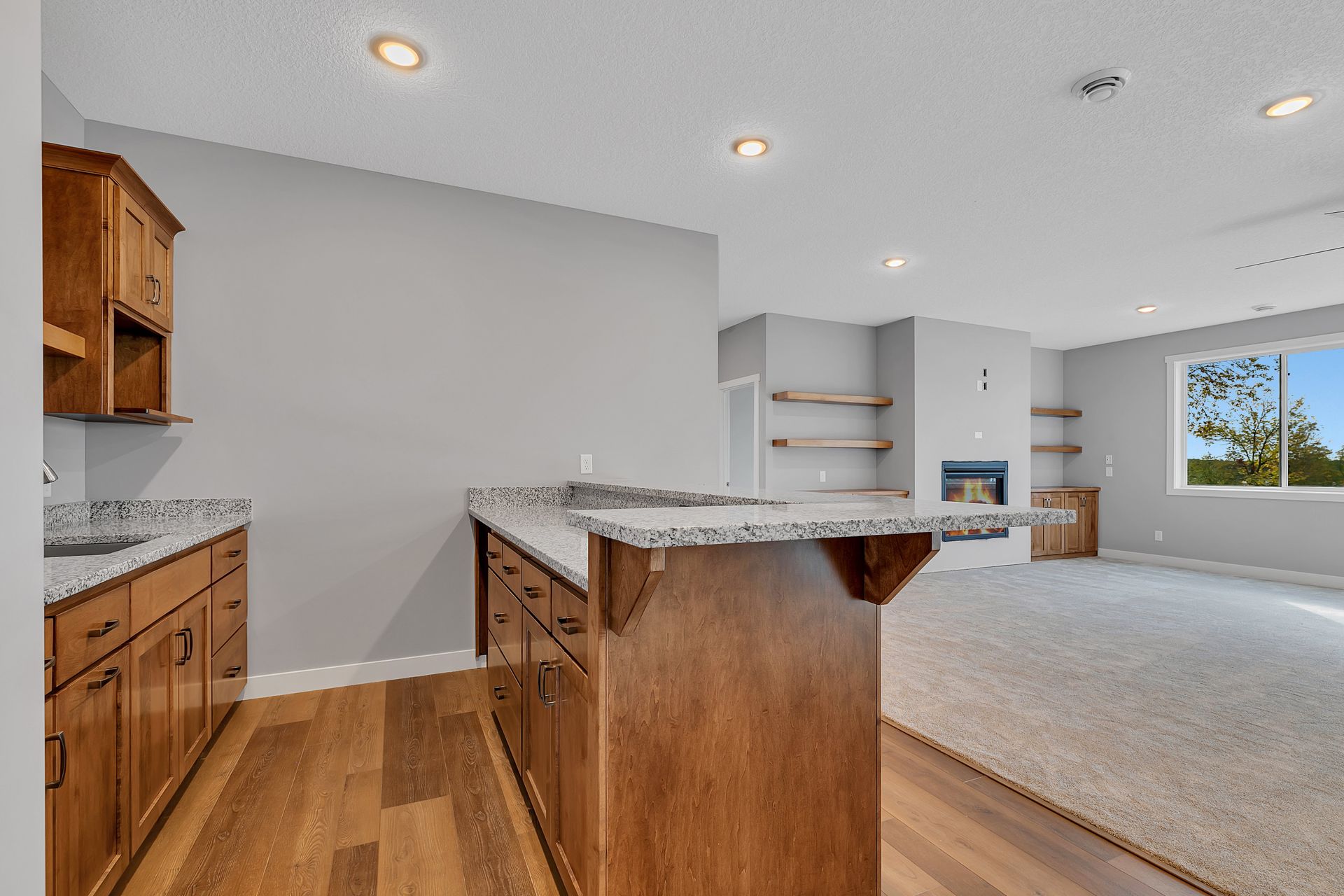 A kitchen with wooden cabinets and a granite counter top.