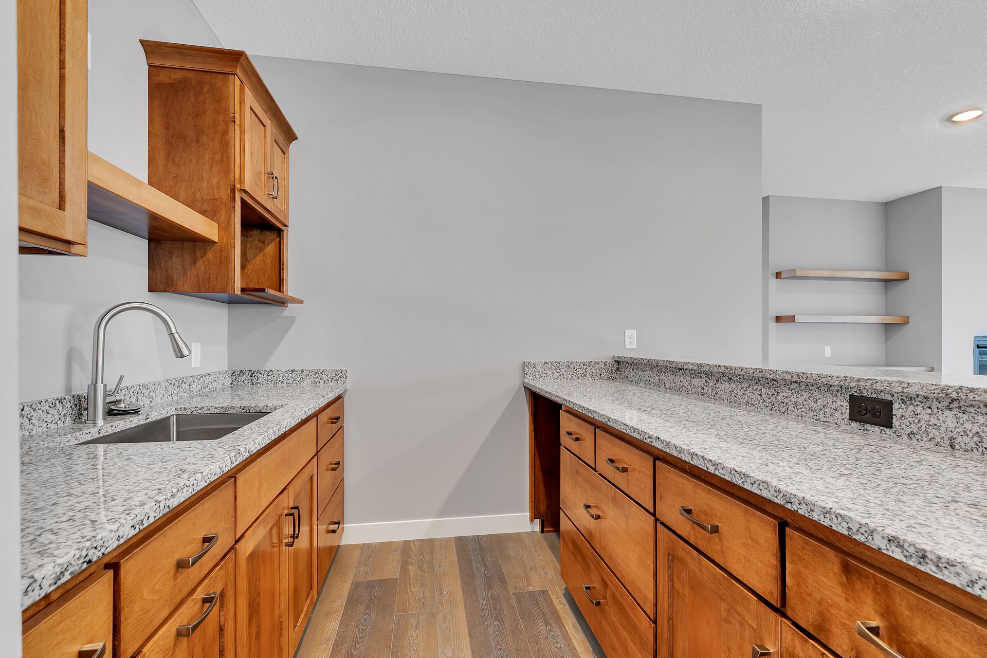 A kitchen with granite counter tops and wooden cabinets.