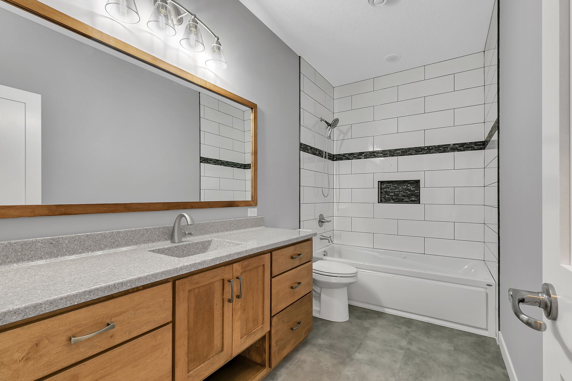 A bathroom with a sink , toilet , tub and mirror.