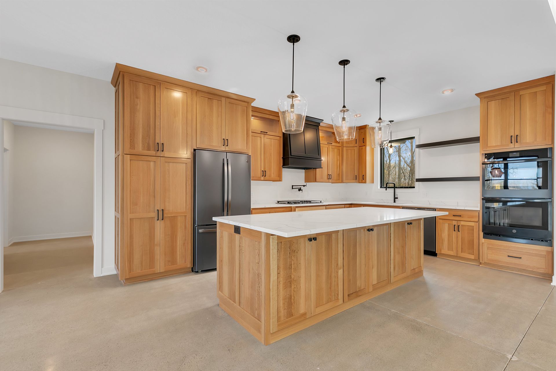 A kitchen with wooden cabinets and a large island in the middle.