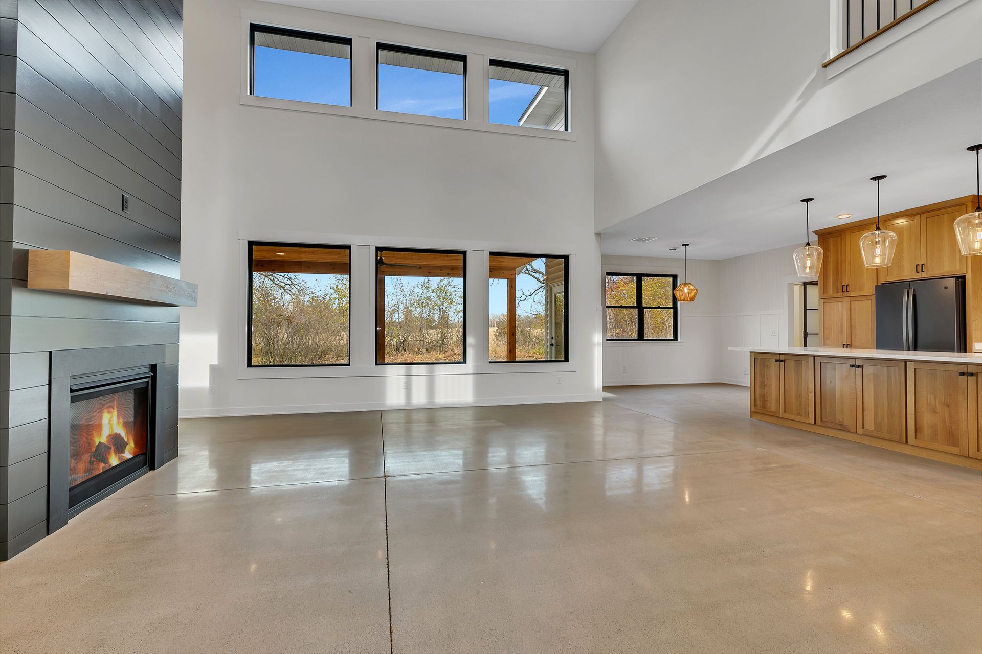 A large empty room with a fireplace and lots of windows