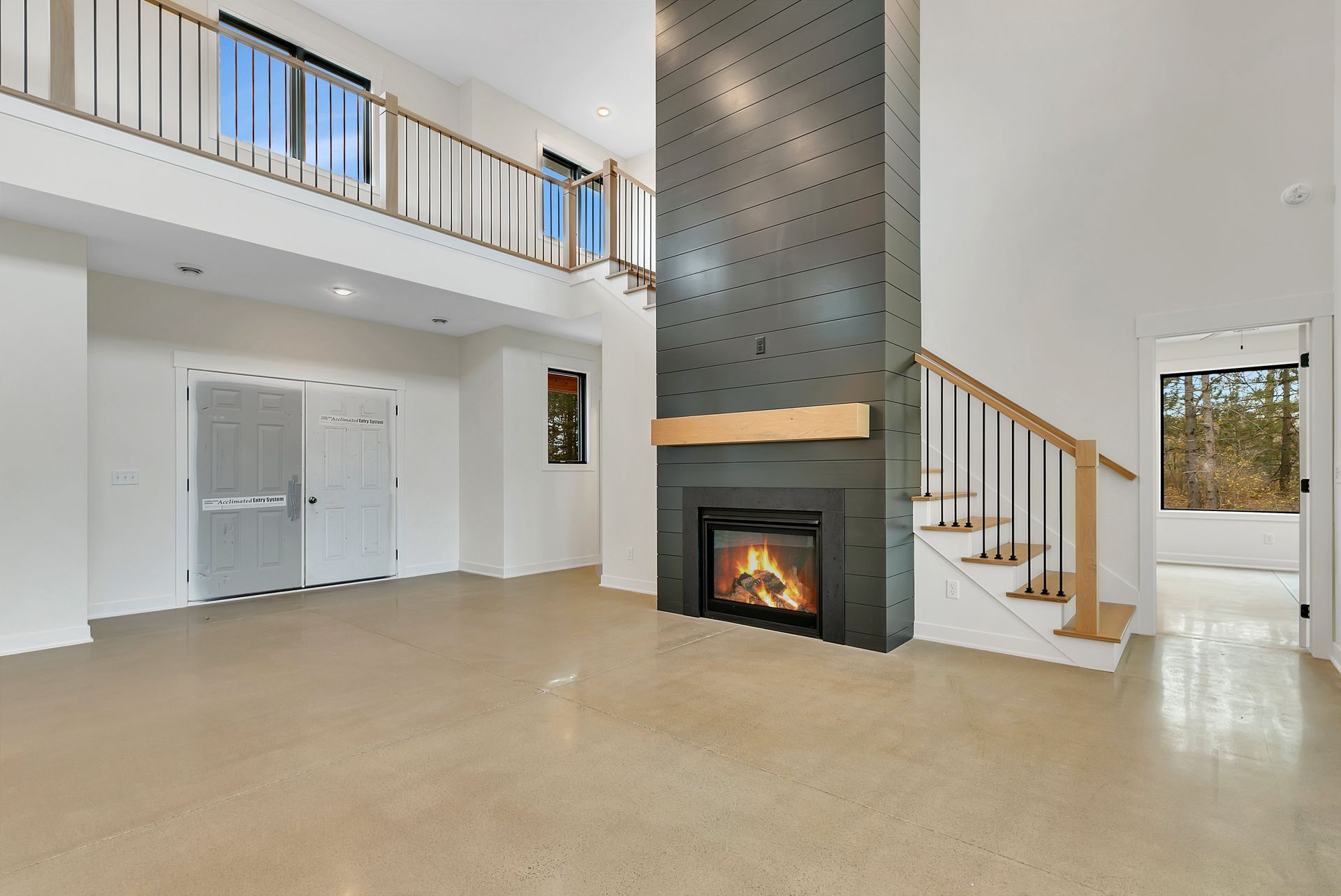 An empty living room with a fireplace and stairs.