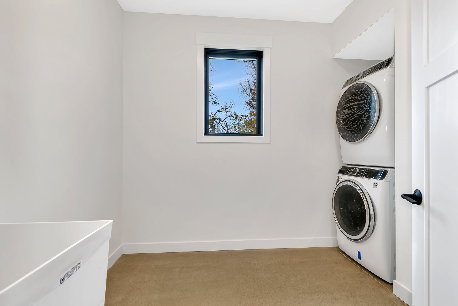A laundry room with a washer and dryer stacked on top of each other.
