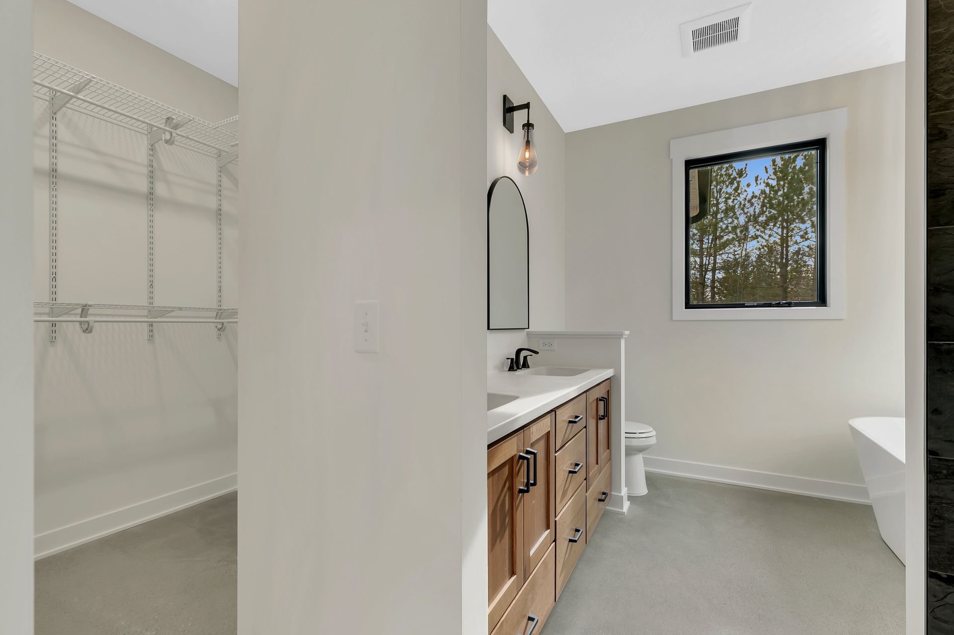 A bathroom with a sink , toilet , and window.