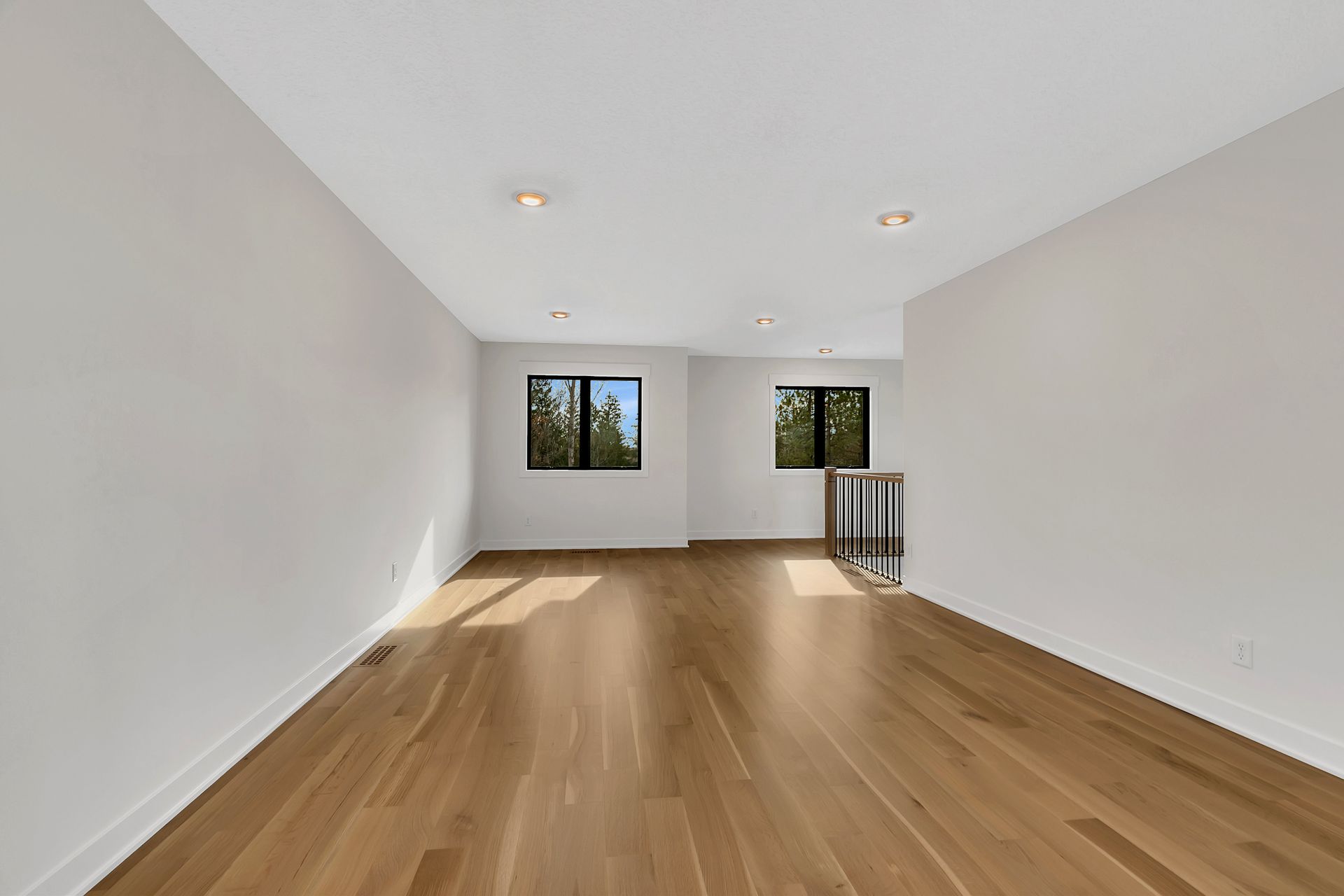 An empty room with hardwood floors and white walls