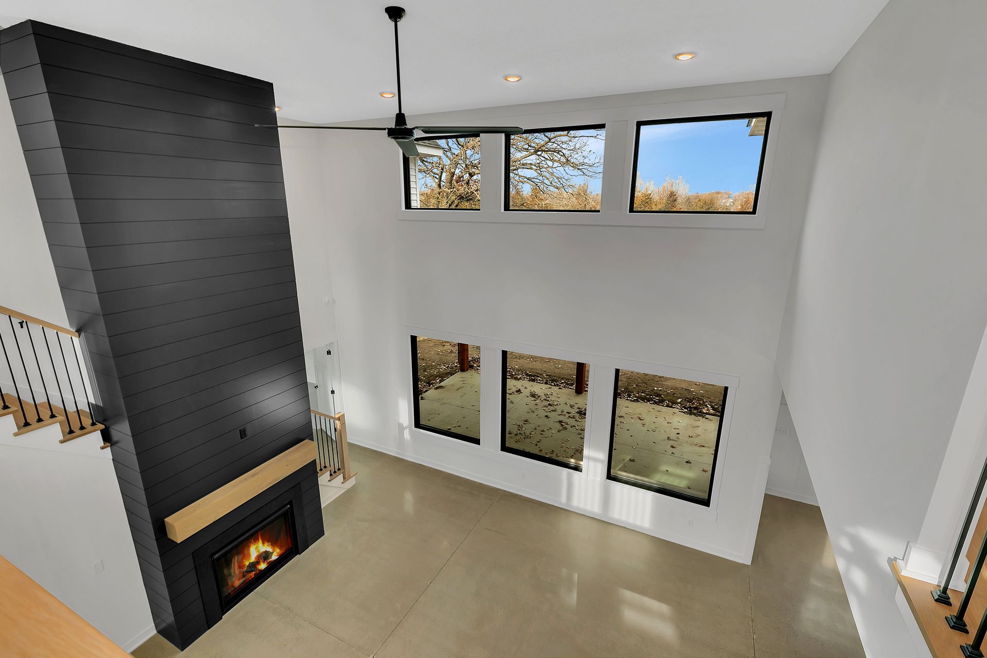 A living room with a fireplace and a ceiling fan.