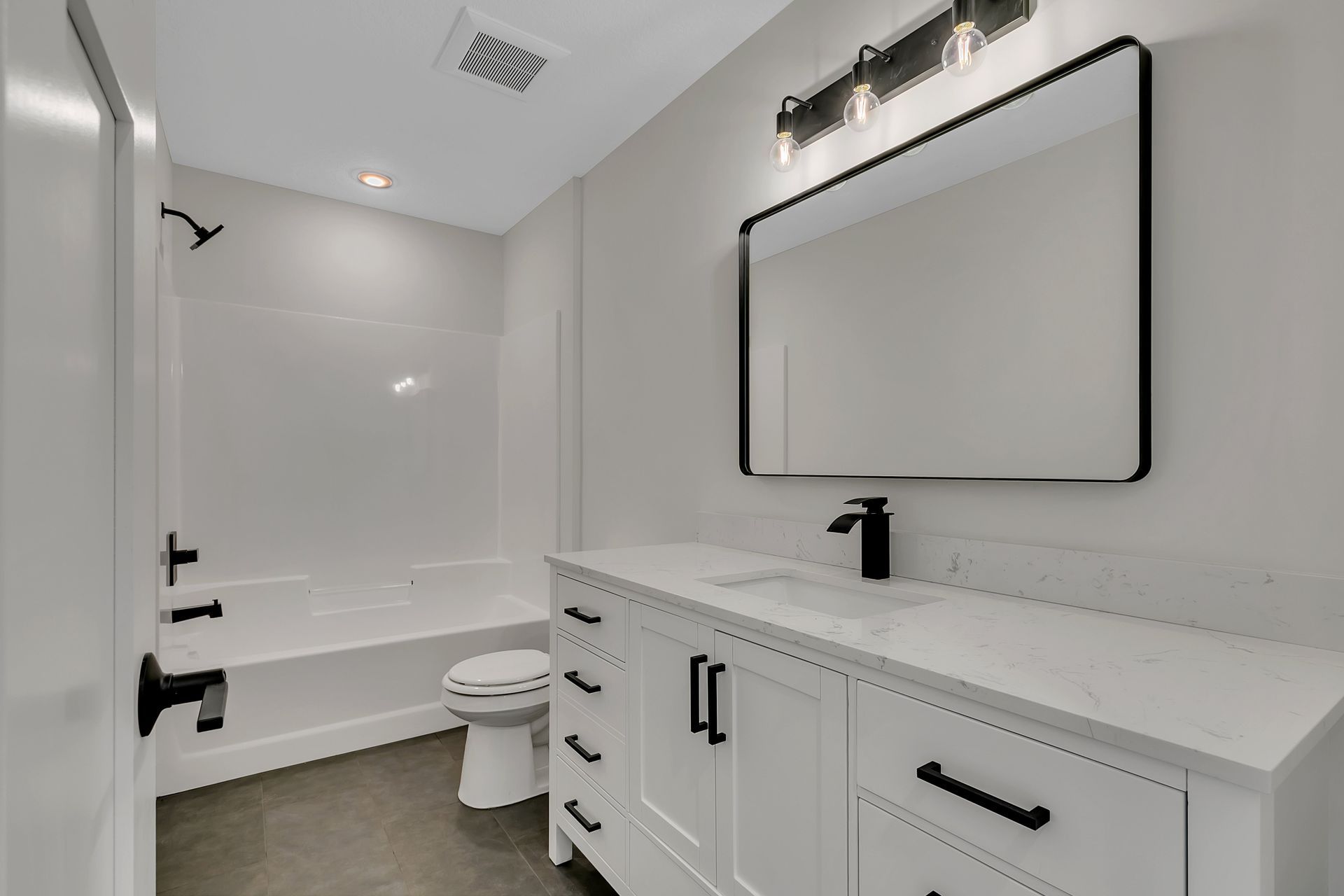 A bathroom with a toilet , sink , and mirror.