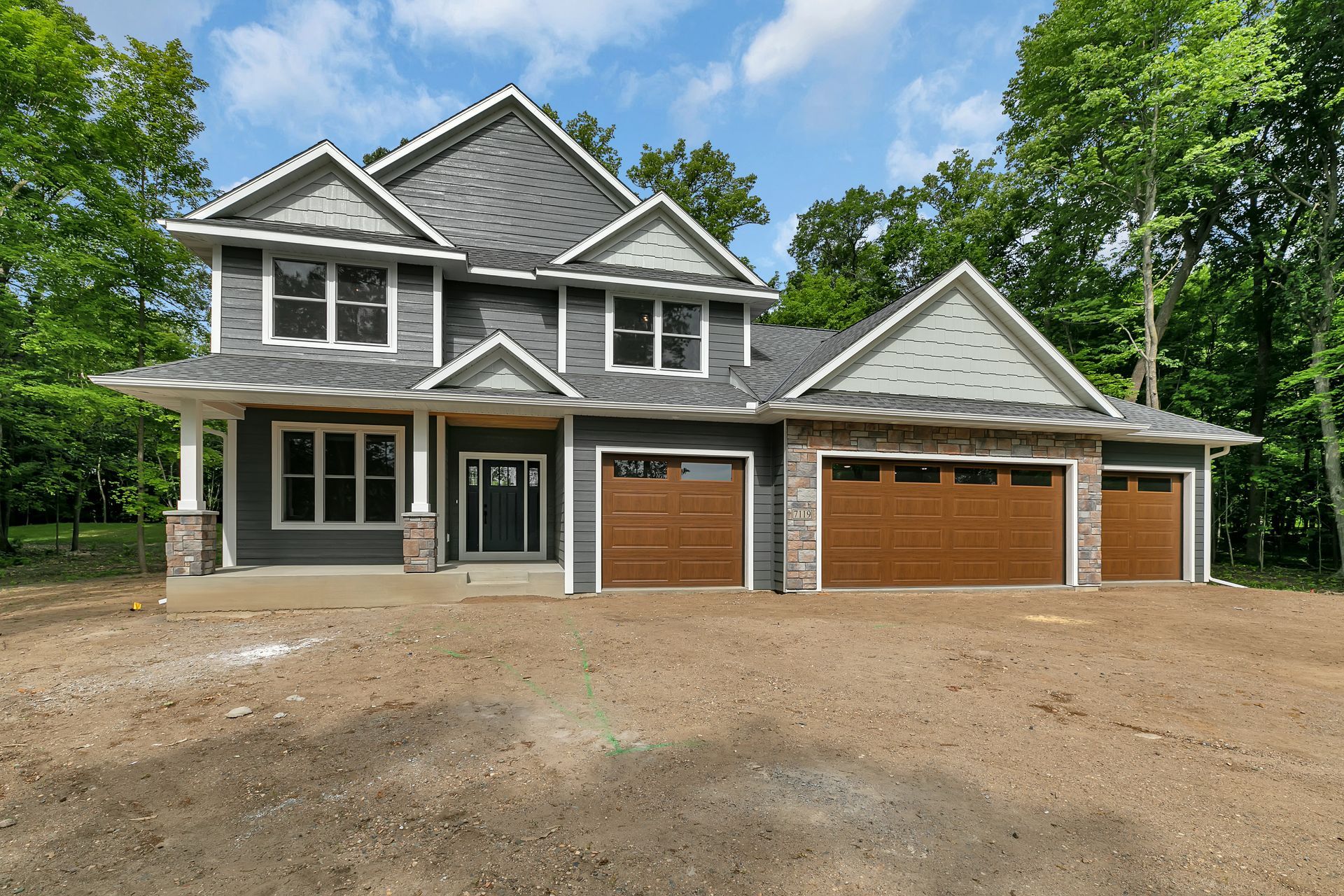 A large house with three garage doors and a lot of windows