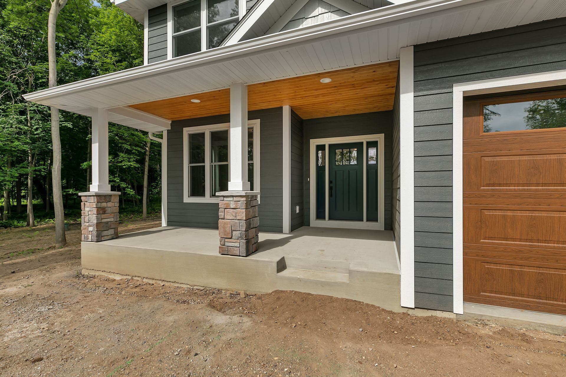 The front of a house with a porch and a garage door.