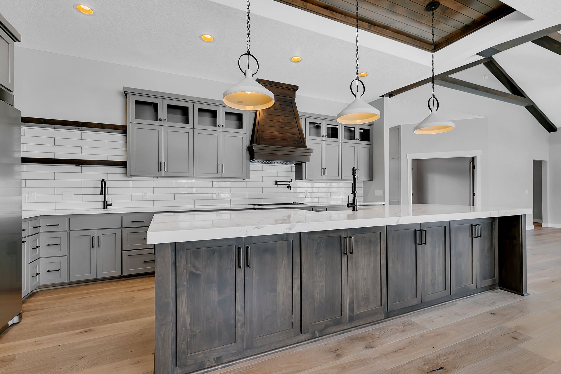 A kitchen with gray cabinets and a large island in the middle.