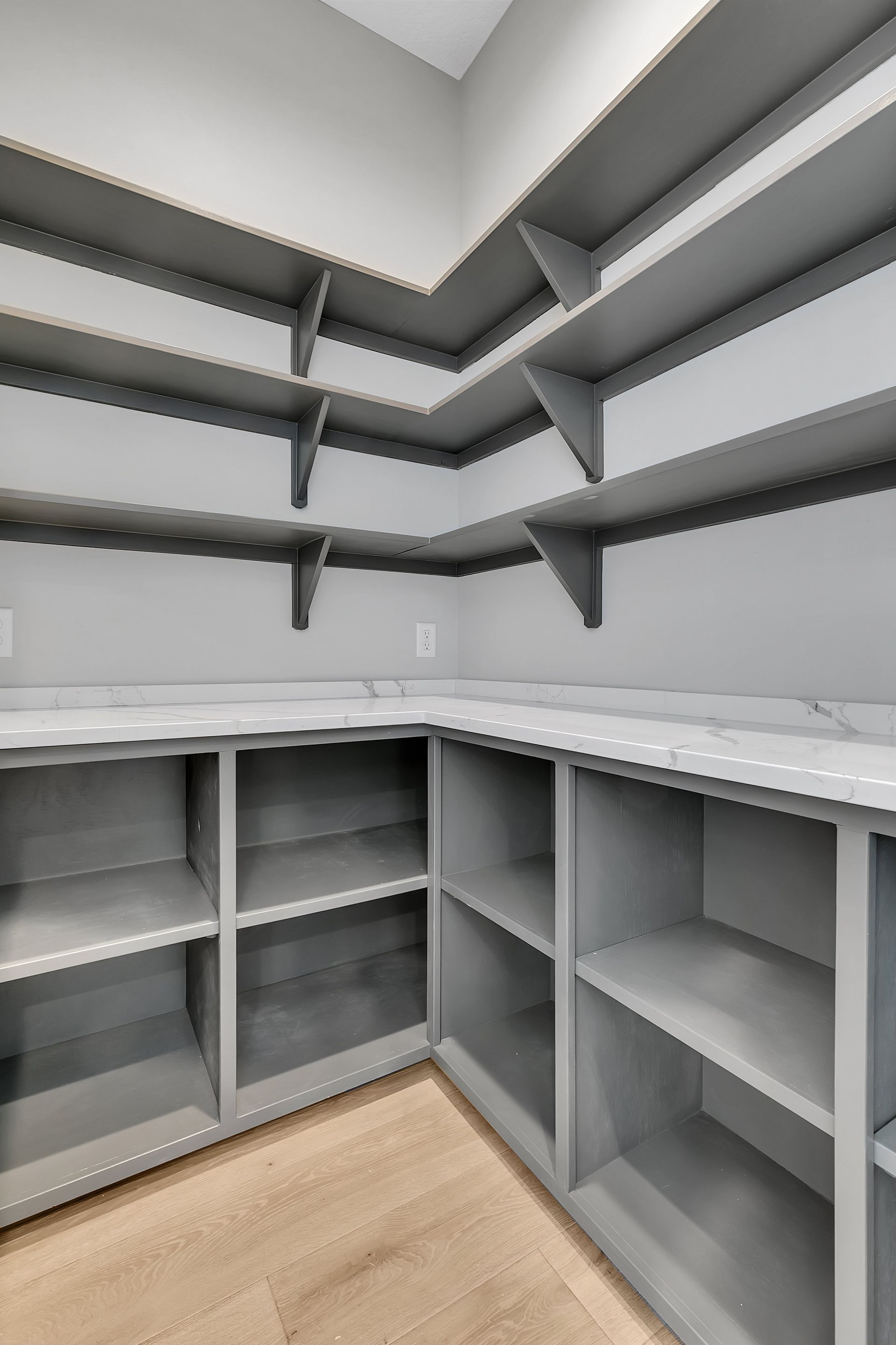 A pantry with lots of shelves and a counter top.