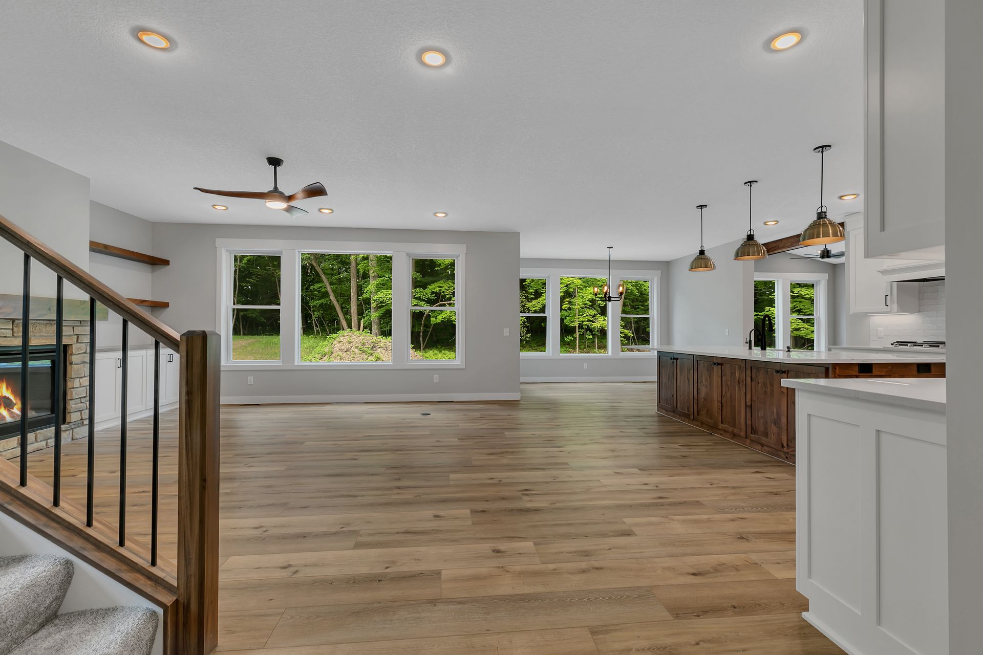 A large empty living room with hardwood floors and a fireplace.