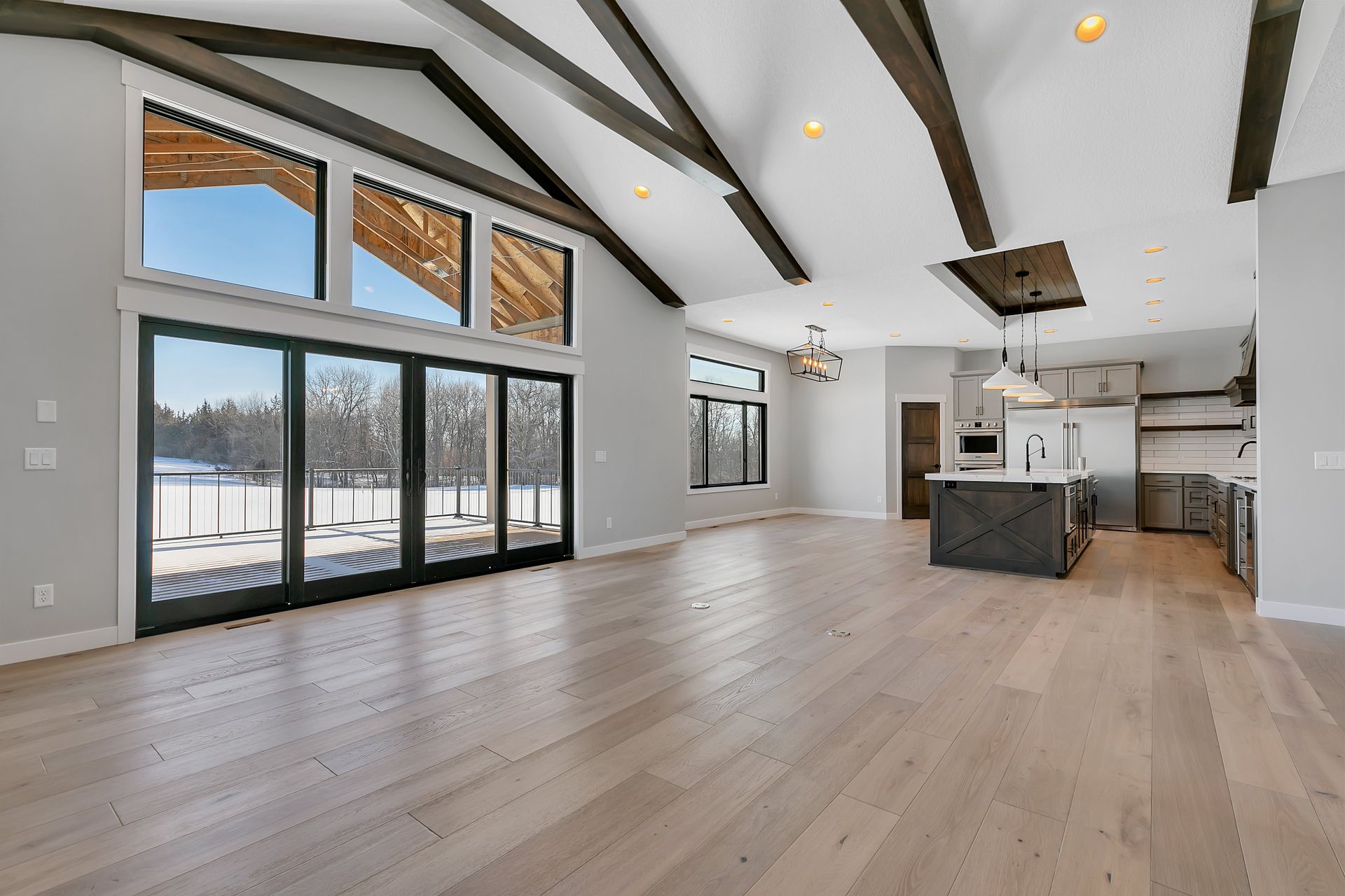 A large empty room with a lot of windows and hardwood floors.