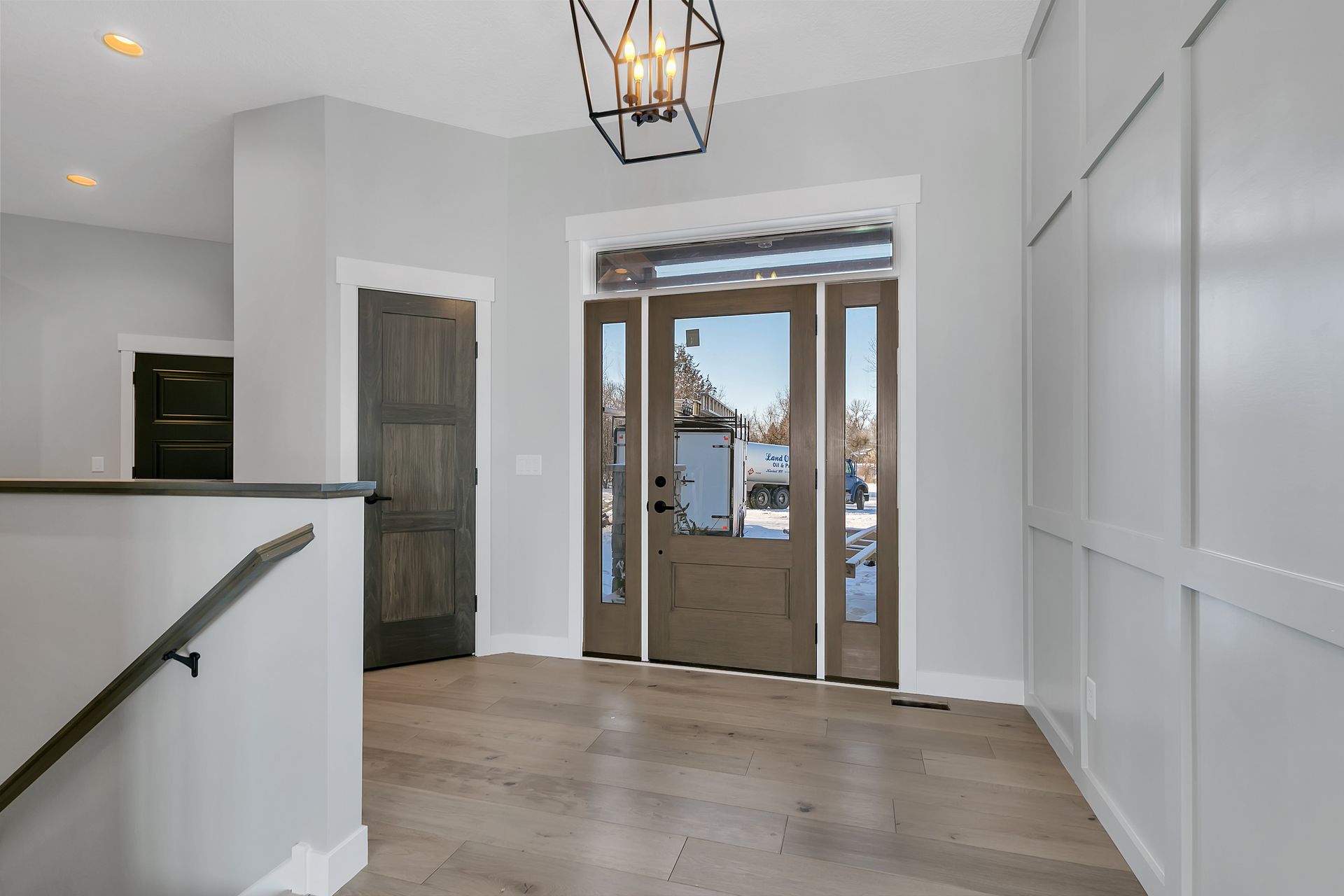A hallway with a staircase and a door in a house.