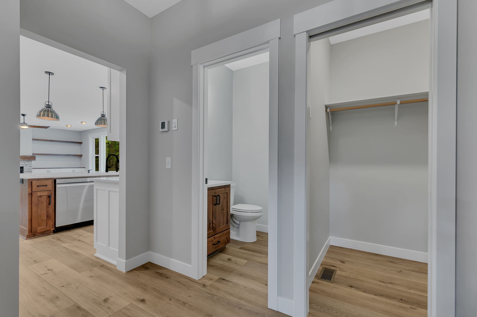 A hallway leading to a bathroom and a walk in closet.