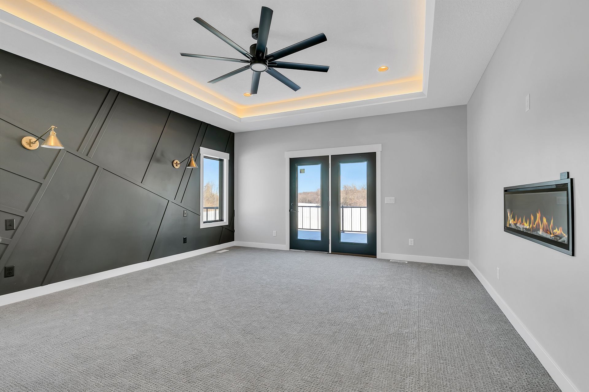 A large empty room with a fireplace and a ceiling fan.