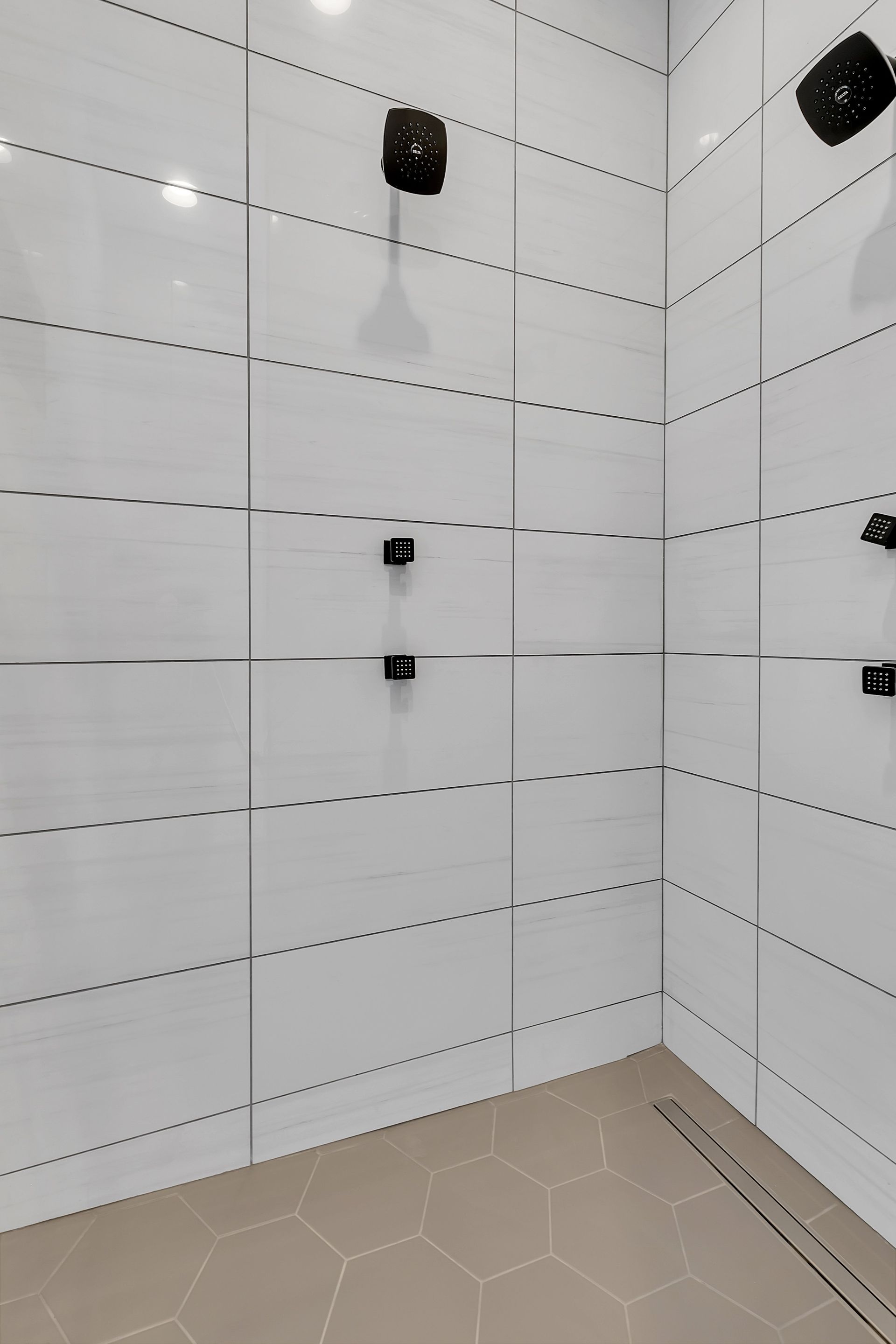 A bathroom with white tiles and a walk in shower