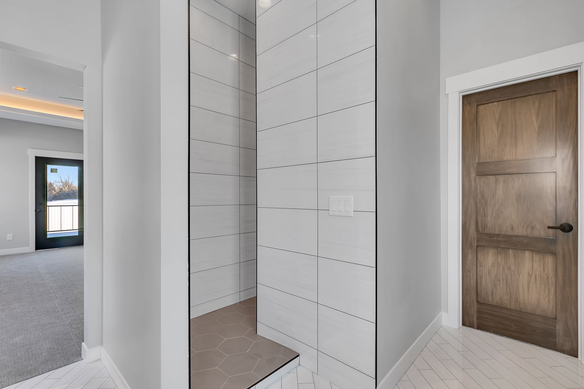 A bathroom with a walk in shower and a wooden door.