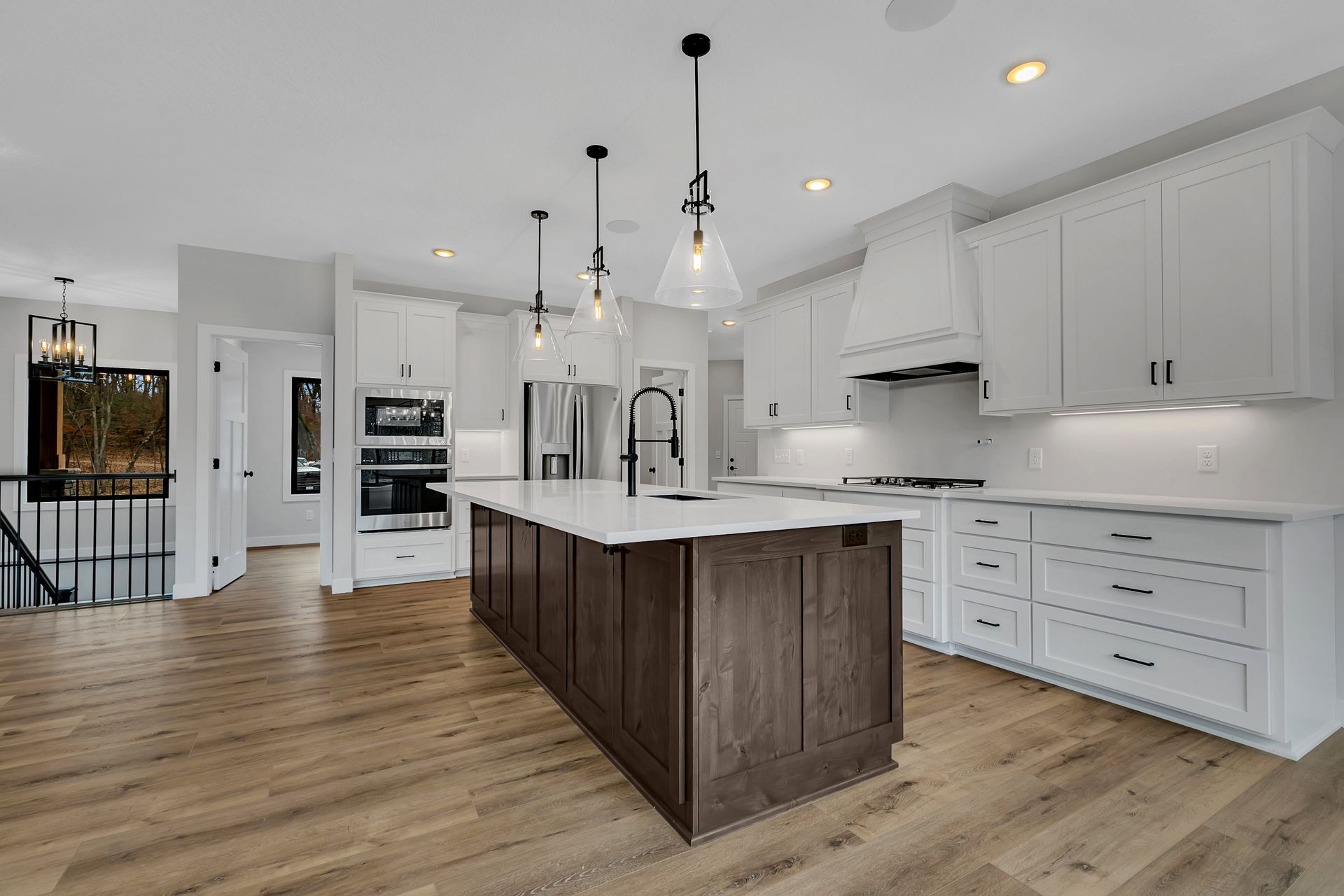 A kitchen with white cabinets and a large island in the middle.