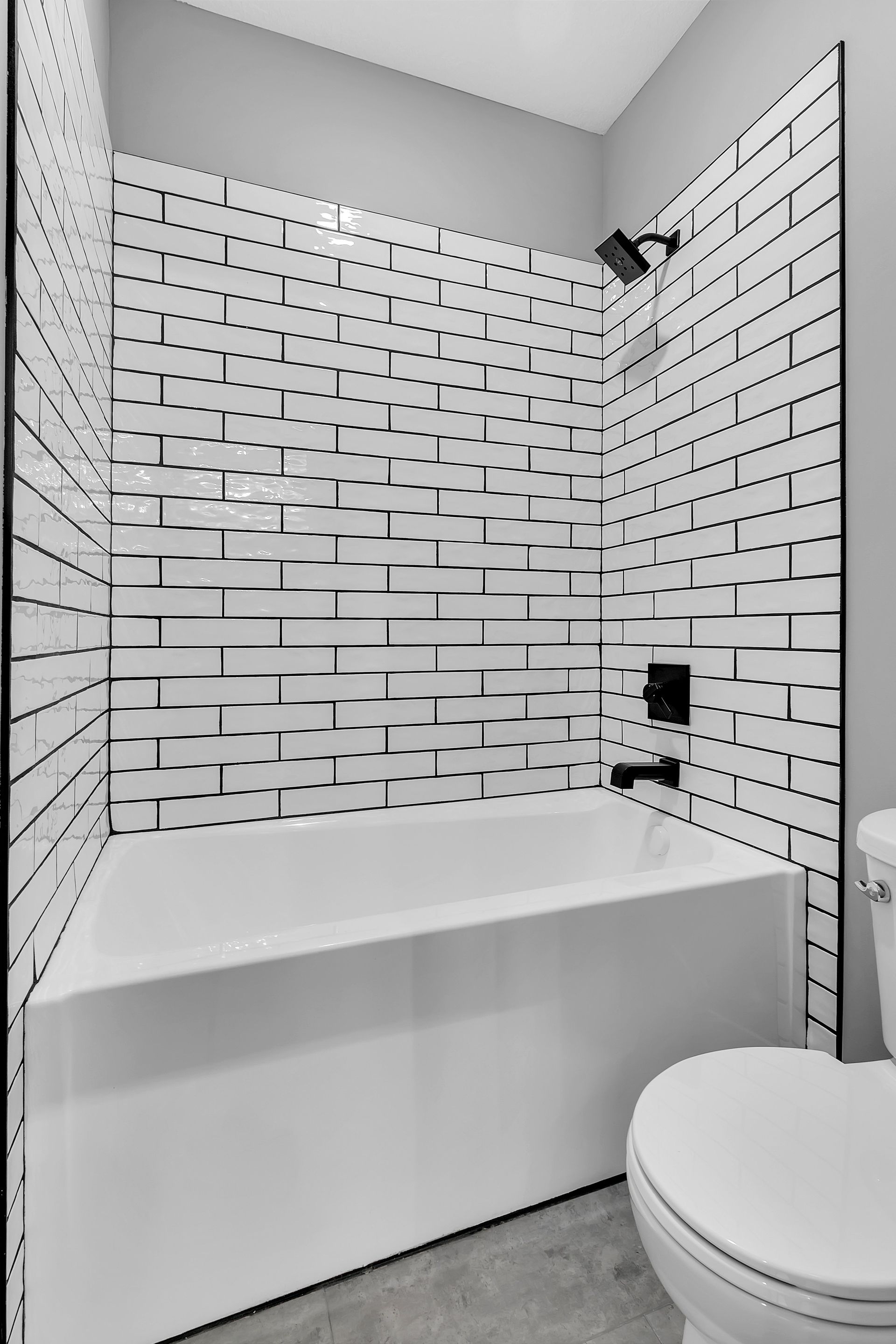 A bathroom with a bathtub , toilet and shower.