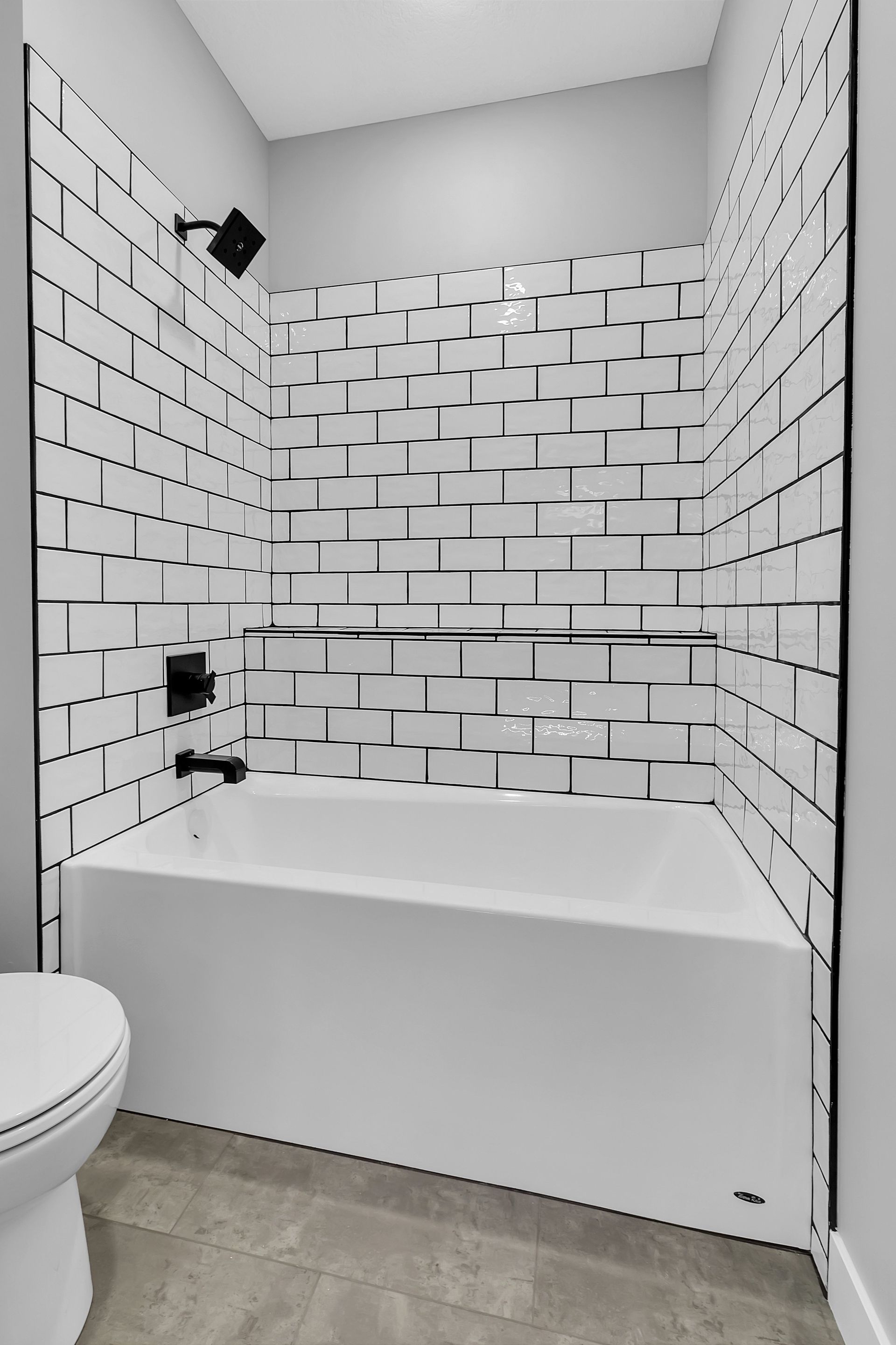 A bathroom with a bathtub , toilet and shower.