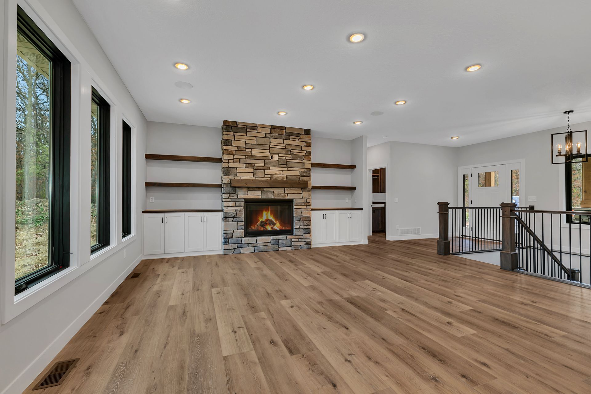 An empty living room with hardwood floors and a fireplace.